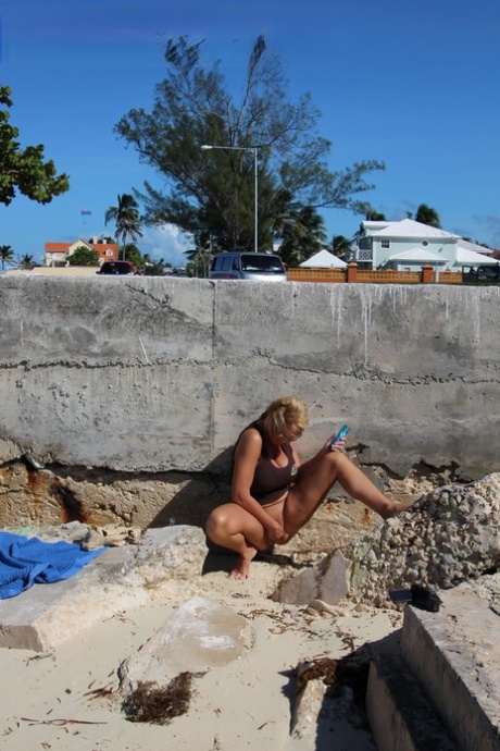 Natural blonde masturbates against a seawall while on vacation in the tropics 82427087